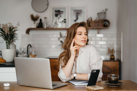 Emotional young woman using her laptop at home. High quality photoの写真素材