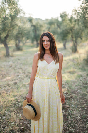 portrait of beautiful young brunette woman in straw hat at sunset in olive garden. Travel to Italy, summer vacation. High quality photoの写真素材