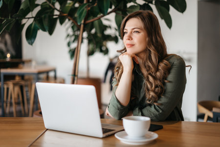 Coffee Break. Positive Business Lady Drinking Hot Drink Relaxing Sitting At Laptop At Workplace. Free Space. High quality photoの写真素材