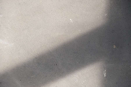 gray concrete wall with shadow. rays of the sun at sunset. abstraction, backgroundの写真素材