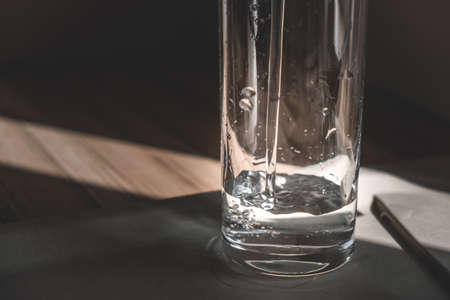 a glass is filled with crystal clear water in the morning sun. a glass of water in the morning. healthy eating, health careの写真素材