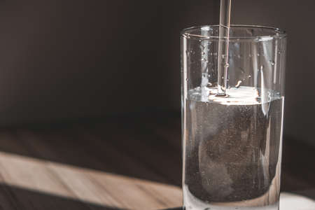 a glass is filled with crystal clear water in the morning sun. a glass of water in the morning. healthy eating, health careの写真素材