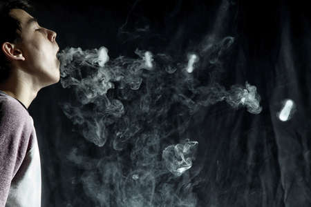 Vape trick rings in performance of vaper on dark background