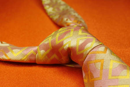 Bright pink with yellow necktie on orange background, fashion accessory close upの写真素材