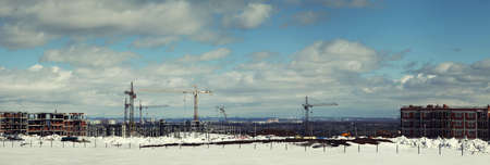 Panorama of construction site with building cranes against the background of cityscapeの写真素材