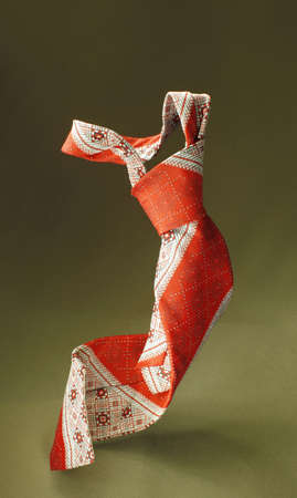 Red with white necktie on green fabric background, fashion accessory close upの写真素材