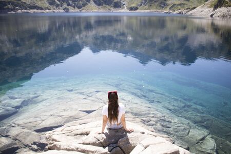 Girl sitting in front of a lake