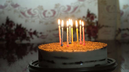 Birthday cake with colorful burning candle in dark. Cake: Birthday Cake With candle For Any Birthday.の写真素材