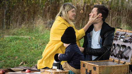 Young family at a picnic in the park on a sunny day. Family having picnic outdoors. Cute family...