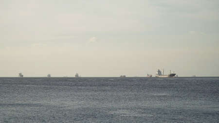 Cargo ships in the Bay of Manila. Large container ship in the sea, blue sky and clouds. Philippines, Manila.の写真素材