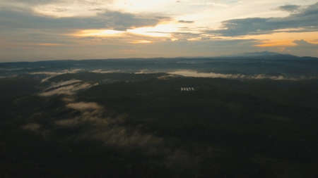 Aerial view of forest, mountains with fog, clouds at sunset on Bali,Indonesia. Tropical rainforest, trees, jungle in mountains. Fog over the jungle. Travel concept.の写真素材