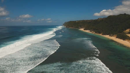 Aerial view of tropical beach with large wave. Large waves of turquoise water crushing on a beach...