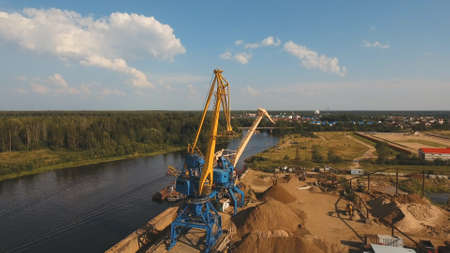 Aerial:port cargo cranes and ship fragment at the docks.Aerial view:Container cranes in cargo port...