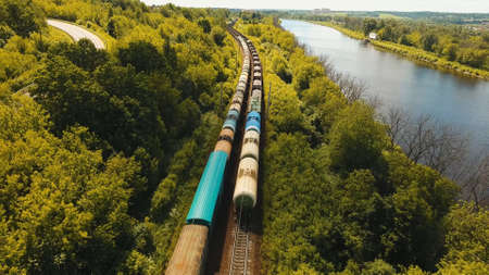 Freight train with cisterns and containers on the railway. Aerial view Container Freight Train, Locomotive in the countryside, Railway and highway.の写真素材