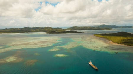 Aerial view: beach, tropical island, sea bay and lagoon, Siargao. Tropical landscape hill, clouds and mountains rocks with rainforest. Azure water of lagoon. Shore Landscape Bay. Seascape. Travel concept.の写真素材