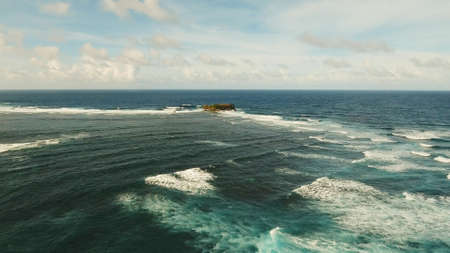 Large rock in the blue sea on a sunny day. Aerial view Rocky cliff in the ocean in the Siargao Island. Seascape: Ocean, sky, sea . Philippines.の写真素材