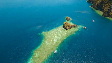 Aerial view: Lagoon with blue, azure water in the middle of small islands and rocks. Beach, tropical...