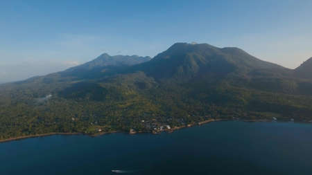 Aerial view coastline on tropical island with sea, trees, palms, Camiguin. Amazingly beautiful landscape with volcanic sand beach, rain forest. Seascape: Ocean and sky. Philippines.Travel conceptの写真素材