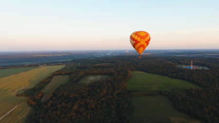 Aerial view Hot air balloon in the sky over a field in the countryside in the beautiful sky and sunset. Balloon silhouette with sunrise, Aerostat fly in the countryside.の写真素材