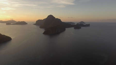 Tropical bay in El Nido sunset. Aerial view: tropical landscape. Sunset sky and mountains rocks of...