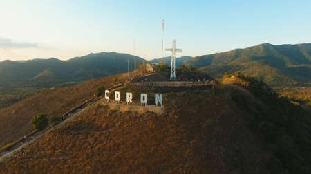The sign of the city of Coron is on a hill, a famous tourist place. Aerial view: Catholic cross on a hill, mountain in the town of Coron, Philippines,Palawan Busuanga. Travel concept.の写真素材