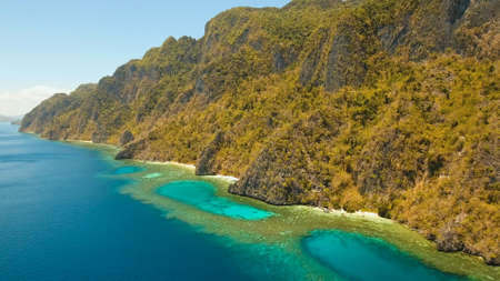Aerial view: Lagoon with blue, azure water in the middle of small islands and rocks. Beach, tropical island, sea bay and lagoon, mountains with forest, Palawan, Coron. Busuanga. Seascape, tropical landscape. Philippines. Travel conceptの写真素材