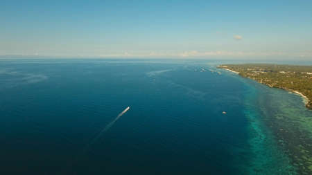 Aerial view of motor boat in sea. Aerial image of motorboat floating in a turquoise blue sea water....