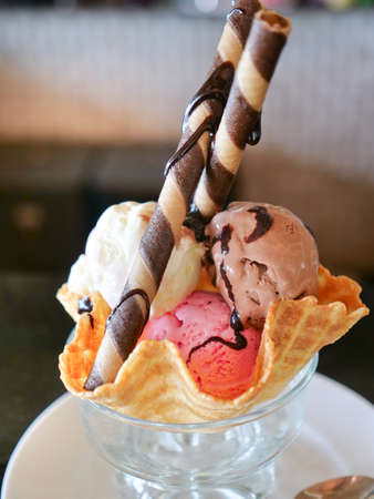 Mixed ice cream scoops in wafer bowl. Dessert Sundae with Neapolitan Flavors of Ice Cream - Glass...