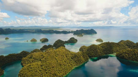 Aerial view: beach, tropical island, sea bay and lagoon, Siargao. Tropical landscape hill, clouds and mountains rocks with rainforest. Azure water of lagoon. Shore Landscape Bay. Travel concept.の写真素材