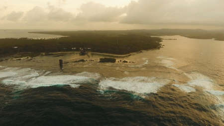 Viewpoint in the ocean at Cloud Nine surf point at sunset, Siargao island , Philippines. Aerial view...