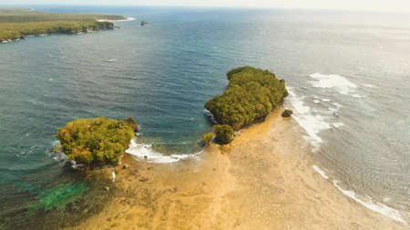 Aerial view: sea and the tropical island with rocks, beach and waves. Coastline of the tropical...