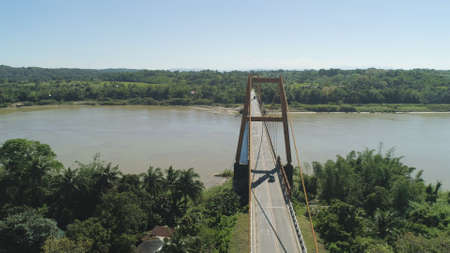 Aerial view of modern bridge with cars over tropical river in mountain province Philippines,Luzon.