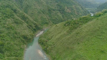 Aerial view of mountain river in the cordillera gorge, mountains covered forest, trees. Cordillera region. Luzon, Philippines. Mountain landscape in cloudy weather.の写真素材