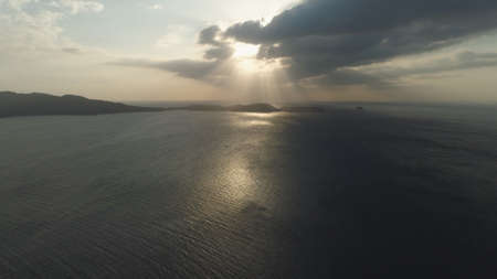 Aerial view of coast of the island at sunset, sunshine with glare on surface water at sunset....