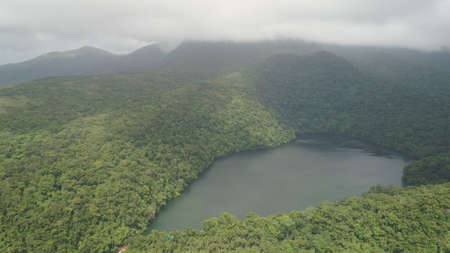 Aerial view of lake Bulusan in the mountains with green rain forest. Lake hidden in the jungle mountains near the volcano Bulusan. Tropical landscape with forest and lake. Philippines, Luzonの写真素材
