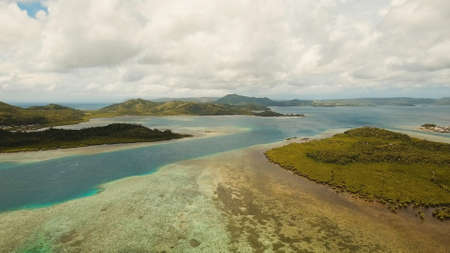 Aerial view: beach, tropical island, sea bay and lagoon, Siargao. Tropical landscape hill, clouds and mountains rocks with rainforest. Azure water of lagoon. Shore Landscape Bay. Seascape. Travel concept.の写真素材