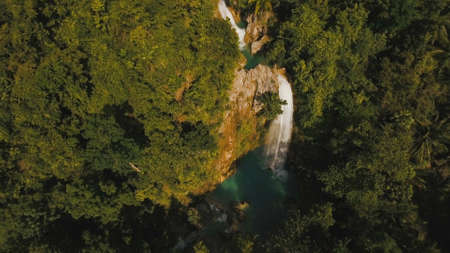 Beautiful waterfall in green forest in jungle, Cebu. Aerial view:tropical rain forest with waterfall.Waterfall with natural swimming pool in a mountain river canyon. Philippines. Travel concept.の写真素材