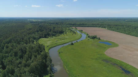 Aerial view summer landscape, river among trees, farmlands. Countryside with forest, the banks river...