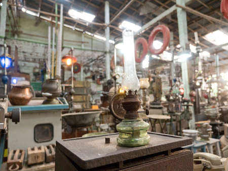 An old, vintage lamp with a shade in an antique store. Antiquarian shop with old ancient lamps. Antique street shop in Bali.の写真素材