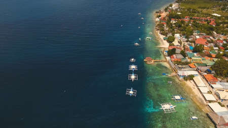 Aerial view of beautifulisland with white sand beach, Moalboal, boats, hotels and tourists. Tropical...