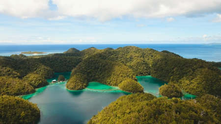 Aerial view: beach, tropical island, sea bay and lagoon, Siargao. Tropical landscape hill, clouds and mountains rocks with rainforest. Azure water of lagoon. Shore Landscape Bay. Travel concept.の写真素材