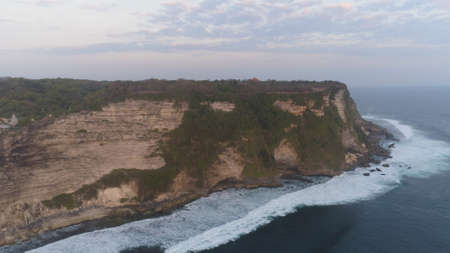 aerial view rocky ocean coastline at sunset. seascape waves break on rocky shore travel concept.