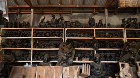 Hindu and Buddhist wooden carving. souvenir shop selling souvenirs and handicrafts of Bali at famous Ubud Market, Indonesiaの写真素材