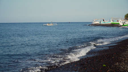 Shore with beach and fishing boats. tropical landscape coastline with black volcanic sand