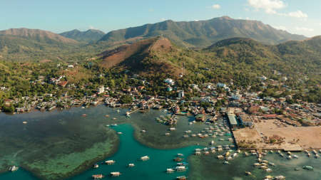 Aerial view Coron city with slums and poor district. sea port, pier, cityscape Coron town with boats on Busuanga island, Philippines, Palawan. Seascape with mountains.の写真素材