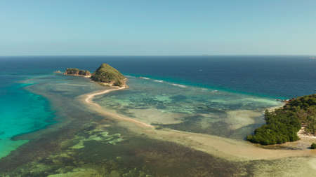 aerial view tropical island in blue lagoon, coral reef and sandy beach. Palawan, Philippines....