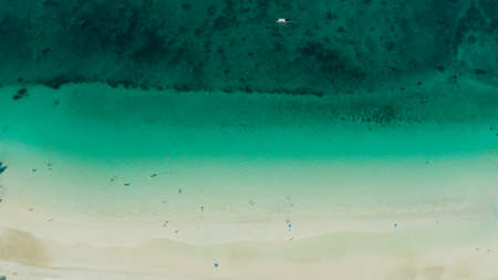 White sandy beach with tourists and azure water of the lagoon,copy space for text, top view. Ocean...