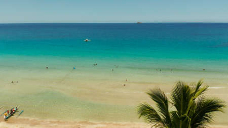 Beautiful tropical beach in cove with blue lagoon and turquoise water. Seascape with sea, sand, palm trees. Nagtabon, Palawan, Philippines. Summer and travel vacation conceptの写真素材