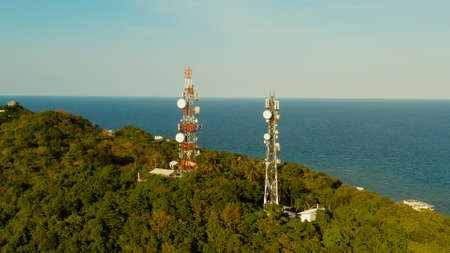 Telecommunication tower, communication antenna in tropical island aerial view. Repeaters on a metal...