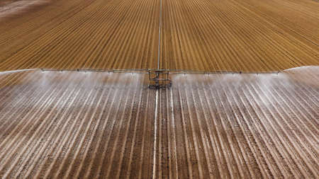 aerial view crop irrigation machine using center pivot sprinkler system. An irrigation pivot watering agricultural land. Irrigation system watering farm land.の写真素材